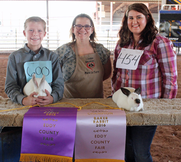 CHAMPION BAKERS - Dorian Cortese, left, and Emily Weddige, right, of the Artesia FFA stand with judge Mary Jo Terry of Cameron, Texas, Tuesday morning after winning Grand Champion and Reserve Champion in the baker rabbit show. (Elizabeth Lewis - Daily Press)