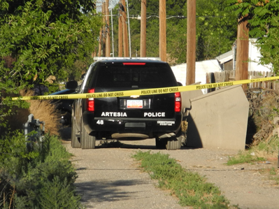 Artesia Police Department officers wait in the alley behind the home on Washington Avenue between 11th and 12th streets this evening as they work to apprehend the suspect, who had barricaded himself inside. (Brienne Green - Daily Press)