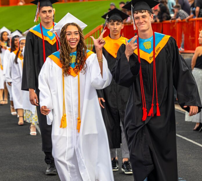 Graduating seniors Ashton Craft and Cael Houghtaling enter the Bulldog Bowl for commencement on Thursday night.