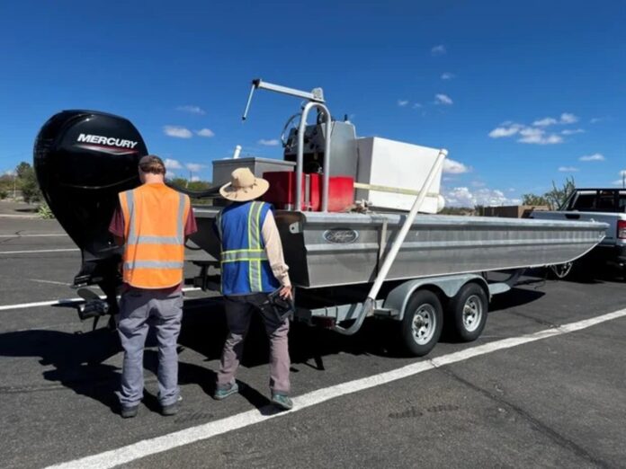 Officials check a boat for invasive species during an inspection.