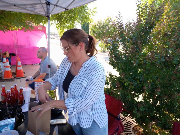 Megan Martin of Martin Acres bags freeze dried fruit for a customer during the June 13, 2026 Oil Patch Market in Artesia.