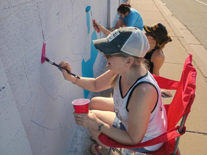 Nancy Dunn from the Artesia Arts Council paints a portion of the third community mural on July 30, 2026.