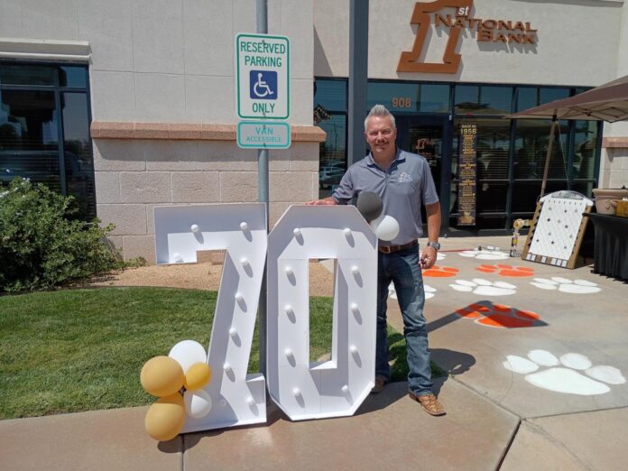 First National Bank Regional Vice President Richie Hood stands next to a display highlighting 70 years of service to southern and southeastern New Mexico.