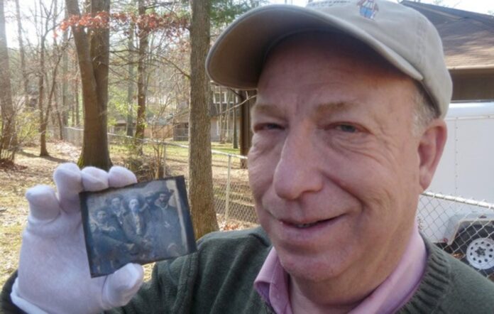 Author Frank Abrams holds a tintype that contains an image of Billy the Kid and his killer, Sheriff Pat Garrett, posing together.