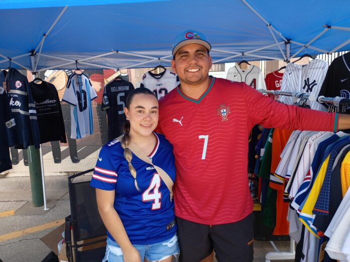 Salana Campos (left) and Juan Campos sold sports jerseys and caps at the Sept. 12, 2026 Oil Patch Market in downtown Artesia.